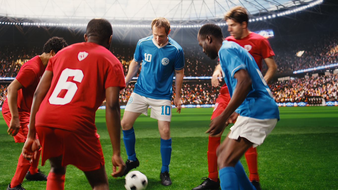 Footballers in red and blue contesting the ball during a match